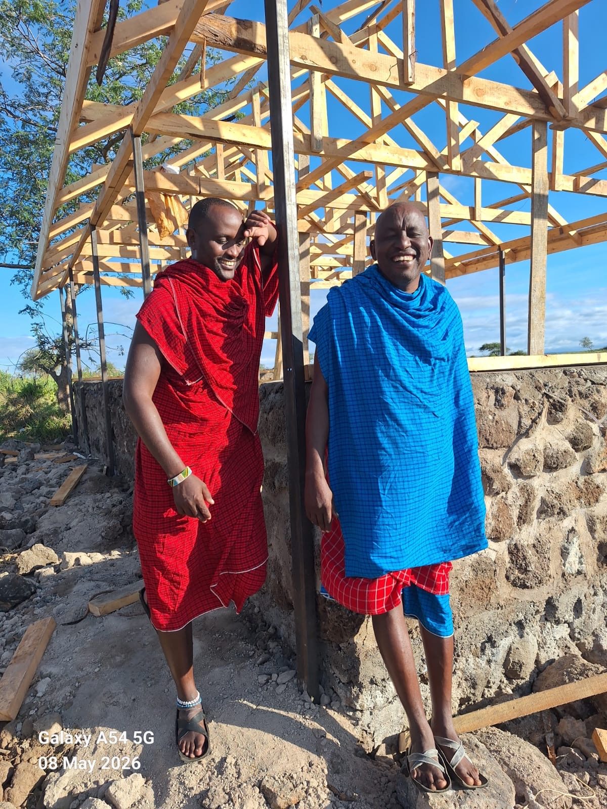 Two Maasai men in front of the building under construction at Isineti