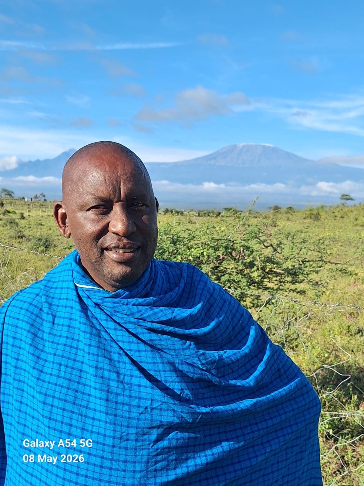 A Maasai elder in the fields at Isineti, with Kilimanjaro behind