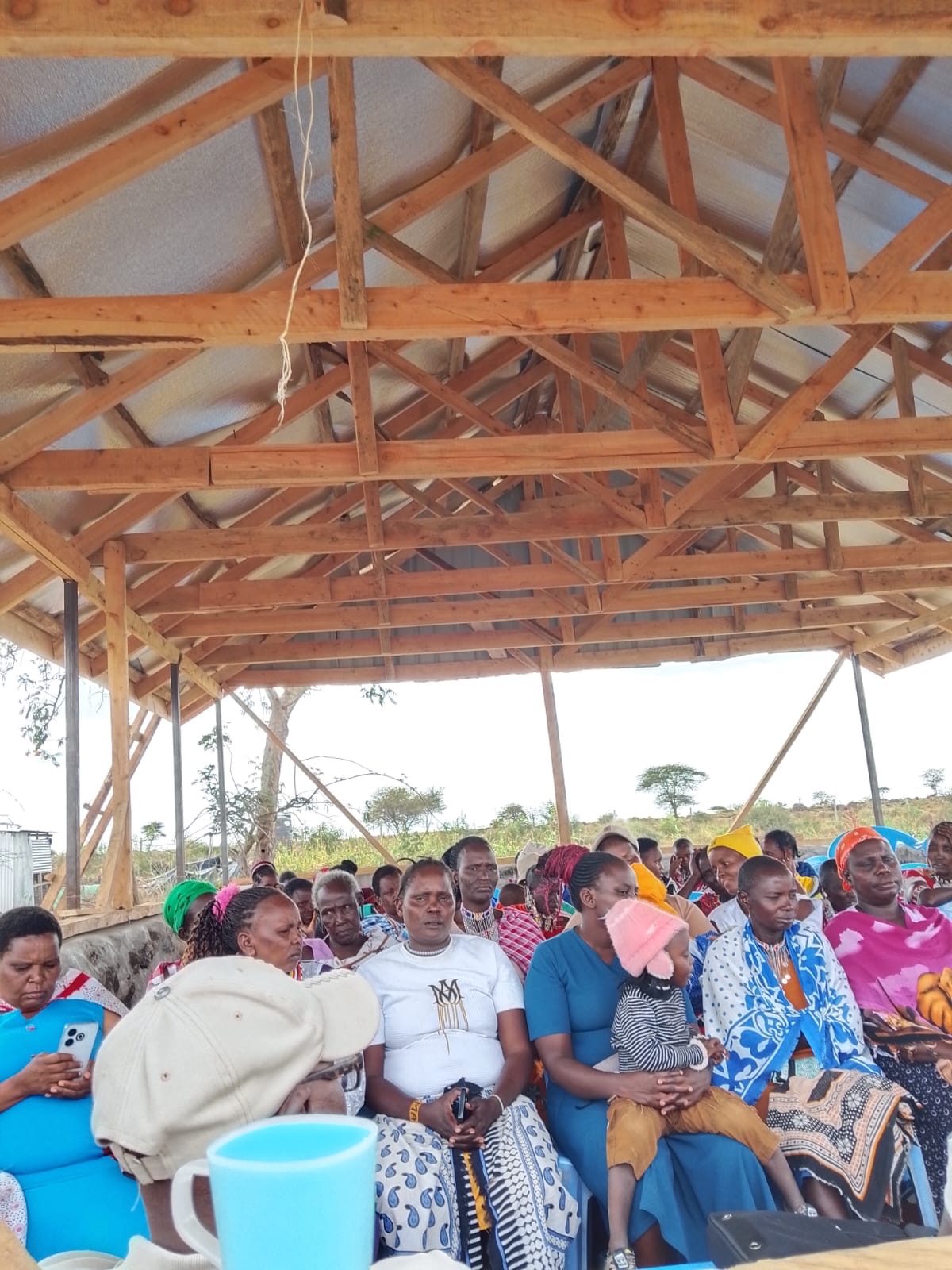 Women seated for the training under the timber roof at Isineti