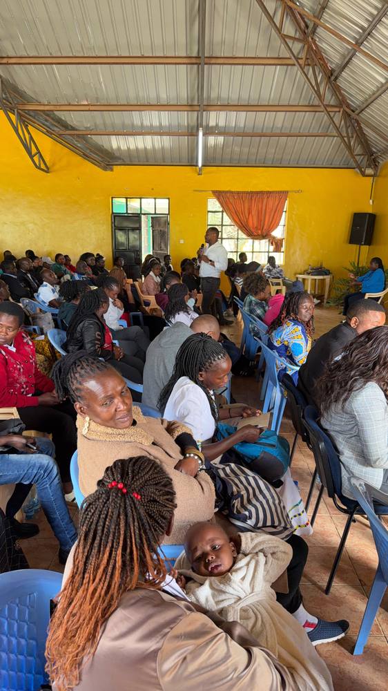 Parents, caregivers and children fill the hall at the Orione Community Training Centre