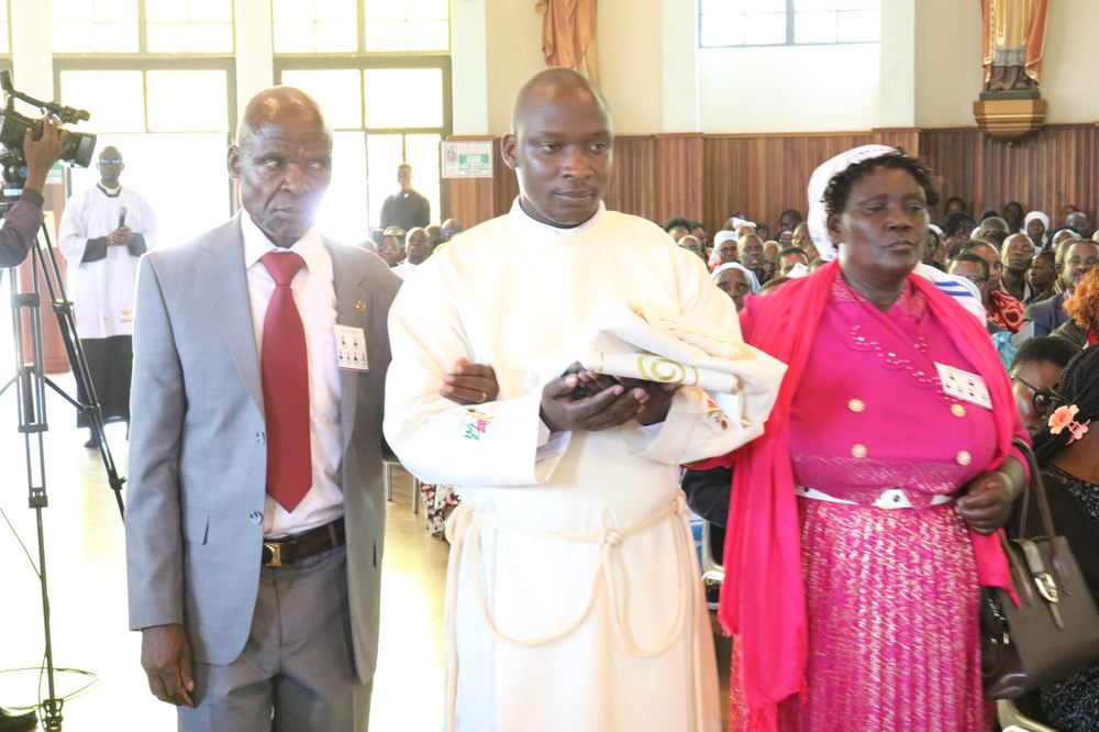 Deacon Justus Nyabuga Barongo led in by his parents