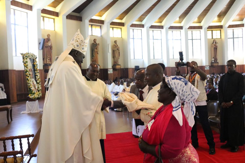 Archbishop Philip Anyolo greeting the parents of Deacon Justus