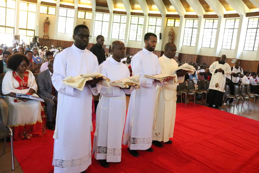 The four newly ordained deacons holding their stoles