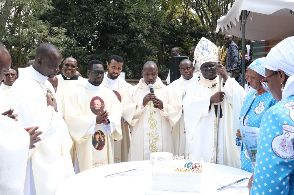 Archbishop Philip Anyolo and the newly ordained at the cake-cutting ceremony