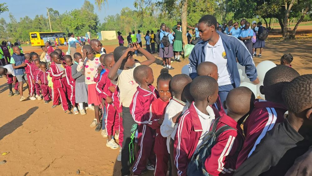 A young learner receives the match ball during the launch of the sports activities