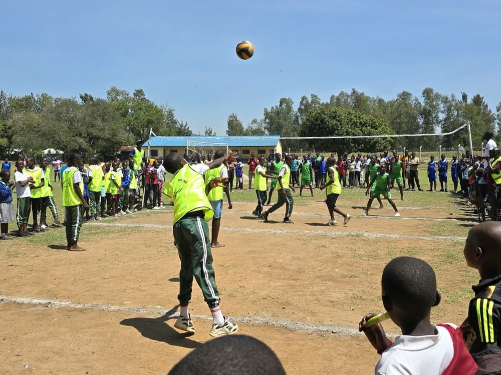 A volleyball serve during a match on the school field